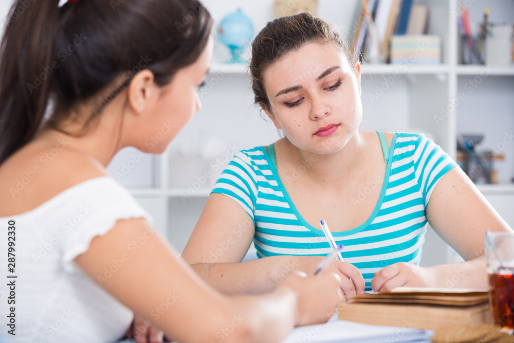 Fototapeta premium Teens girls doing homework and discussing
