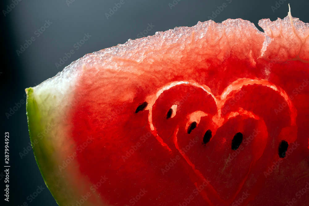 Slice of watermelon with hearts on black background Slice of watermelon with hearts on black background