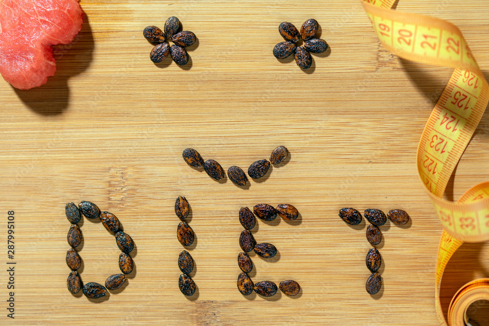 diet word made of seeds and tape measure on wooden board diet word made of seeds and tape measure on wooden board