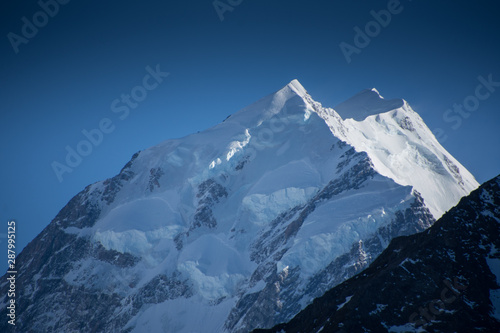 Morning sunlight on Mount Cook/Aoraki on a clear summer day with fresh snow and a deep blue sky