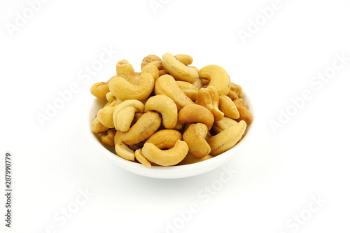 Roasted cashew nuts with salt in dish isolate on white background