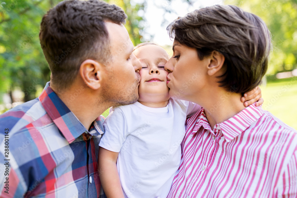 family, leisure and people concept - happy mother and father kissing their little son at summer park family, leisure and people concept - happy mother and father kissing their little son at summer park