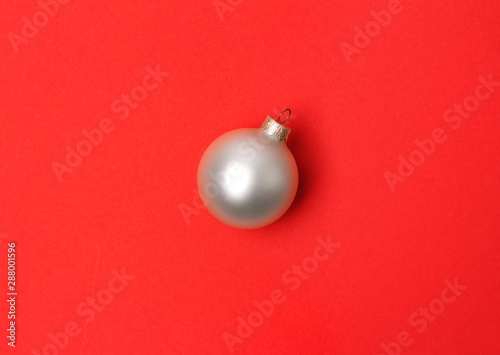 White christmas ball over red paper background.