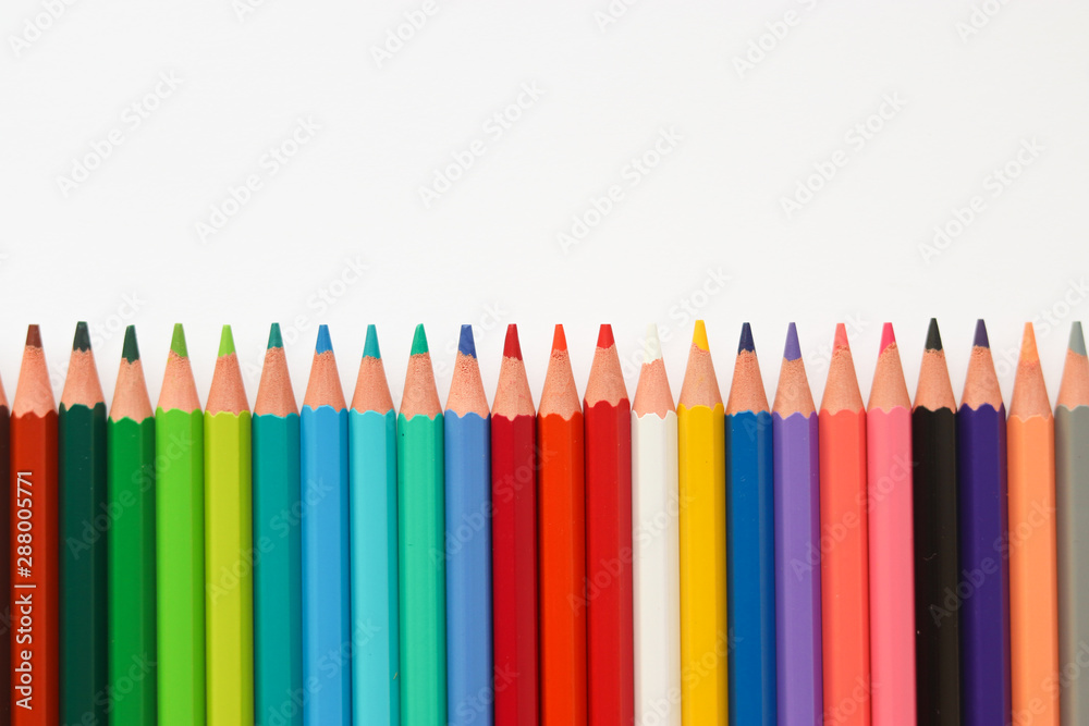 line of colored pencils on a light background. Close-up