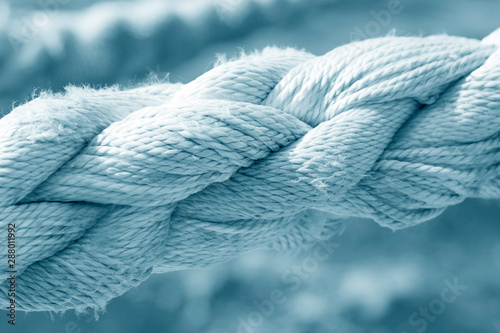 Big rope on a background of blue water close-up,blue toned.
