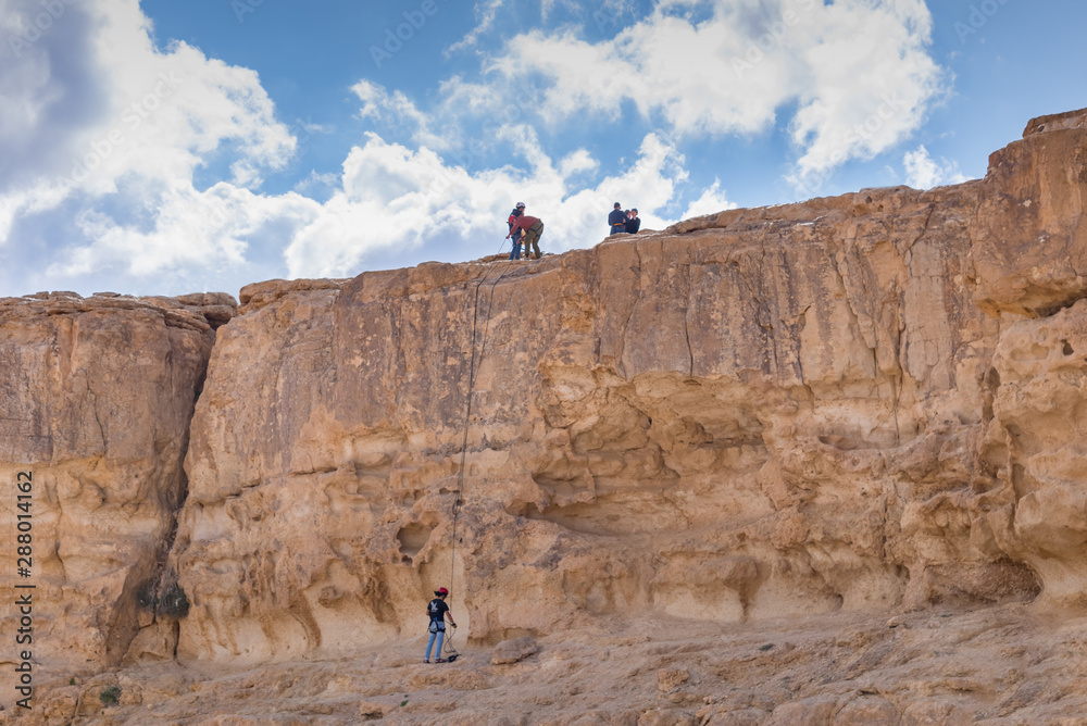 Rock climbers on the cliff of the crater Makhtesh Ramon in Israel's Negev desert. Sports outdoor activities