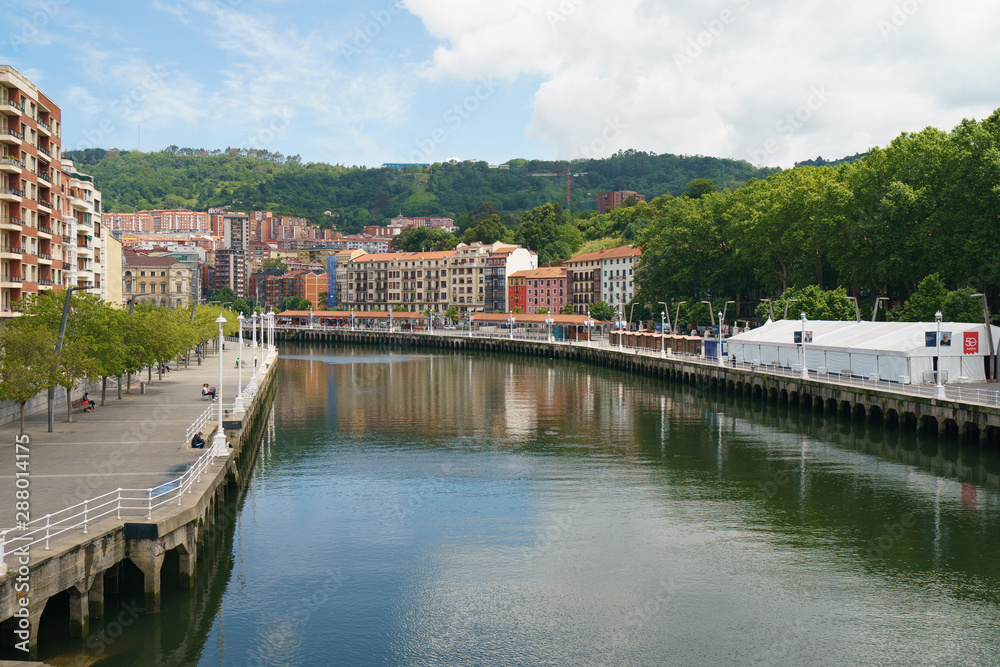 Exterior baroque architecture in Bilbao in Basque country. View from Arenal Bridge over river Nervion / Nerbioi. Lifestyles of the capital in summer sunny day.