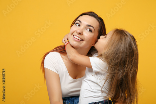 Woman in light clothes have fun with cute child baby girl 4-5 years old. Mommy little kid daughter isolated on yellow background studio portrait. Mother's Day love family parenthood childhood concept.