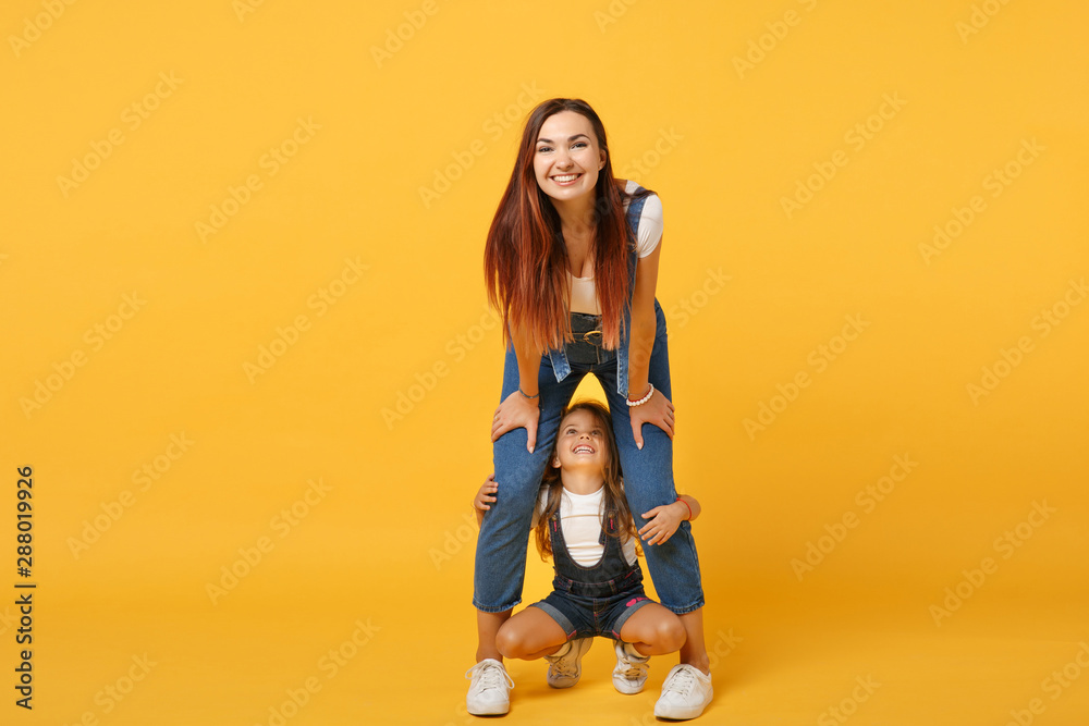 Woman in light clothes have fun with cute child baby girl 4-5 years old. Mommy little kid daughter isolated on yellow background studio portrait. Mother's Day love family parenthood childhood concept. Woman in light clothes have fun with cute child baby girl 4-5 years old. Mommy little kid daughter isolated on yellow background studio portrait. Mother's Day love family parenthood childhood concept.