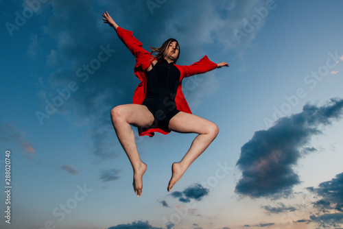 Silhouette of woman jumping during sunset