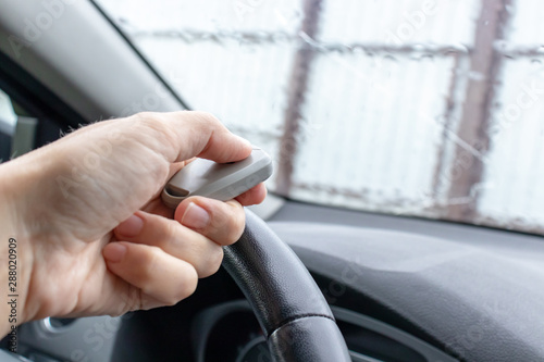 Obraz na płótnie Woman hand inside the car, driver using remote control to open the automatic gat