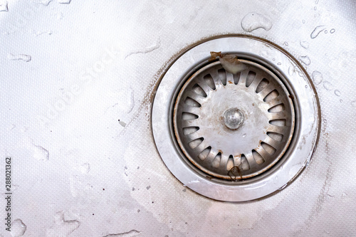 Old rusty calcified drain hole in the kitchen sink with limescale and scurf scum, copy space