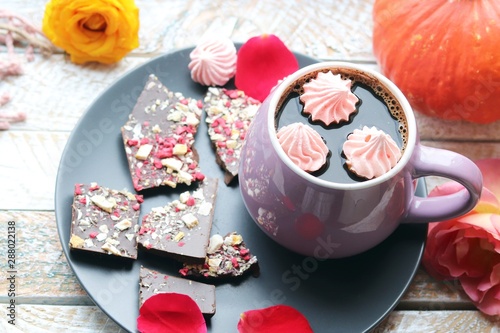  Cup of coffee  chocolate with spices  meringues  roses  pumpkins  leaves on a wooden surface on a window background  home comfort concept  Thanksgiving  autumn season