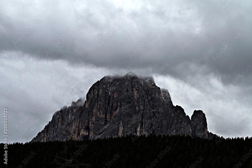 Langkofel after a rainy day, with the Peak covered in clouds. Dramatic look of the Sassolungo in the Dolomites in Val Gardena.