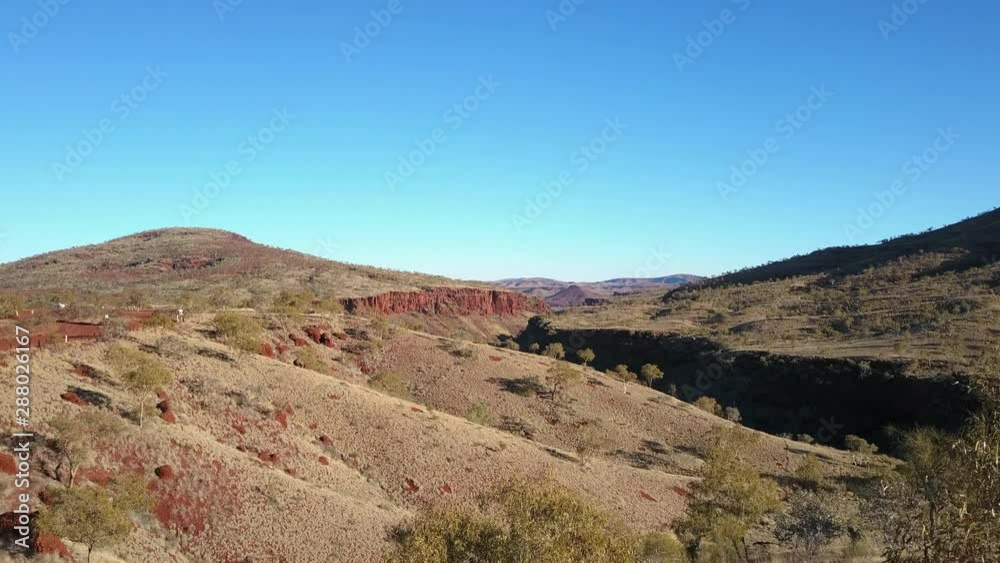 Aerial view of panorama in Pilbara, Western Australia, with green outback landscape, mountains, sunny blue sky as background. Aerial view of panorama in Pilbara, Western Australia, with green outback landscape, mountains, sunny blue sky as background.