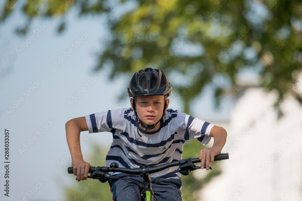 Boy with a bicycle helmet racing on his bicycle through the area Boy with a bicycle helmet racing on his bicycle through the area