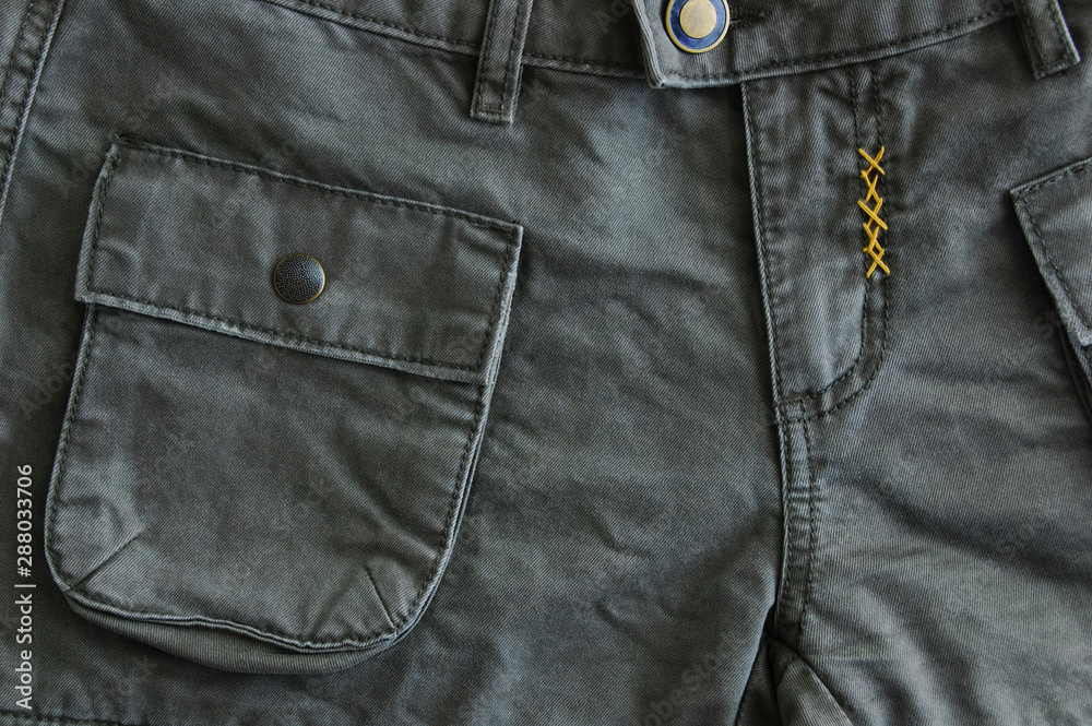 Pockets and flysuit of gray trousers. Work clothes close-up. Pockets and flysuit of gray trousers. Work clothes close-up.