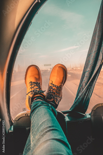  Traveler legs resting in a bus. Lumberjack boots and a view.