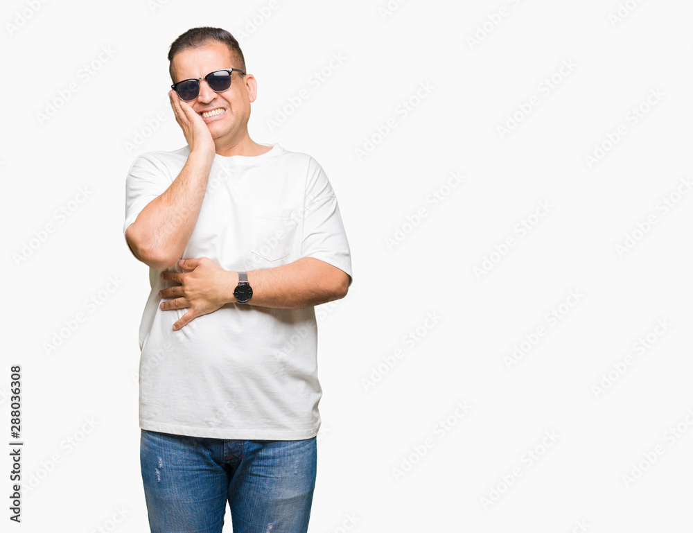 Middle age arab man wearig white t-shirt and sunglasses over isolated background thinking looking tired and bored with depression problems with crossed arms. Middle age arab man wearig white t-shirt and sunglasses over isolated background thinking looking tired and bored with depression problems with crossed arms.