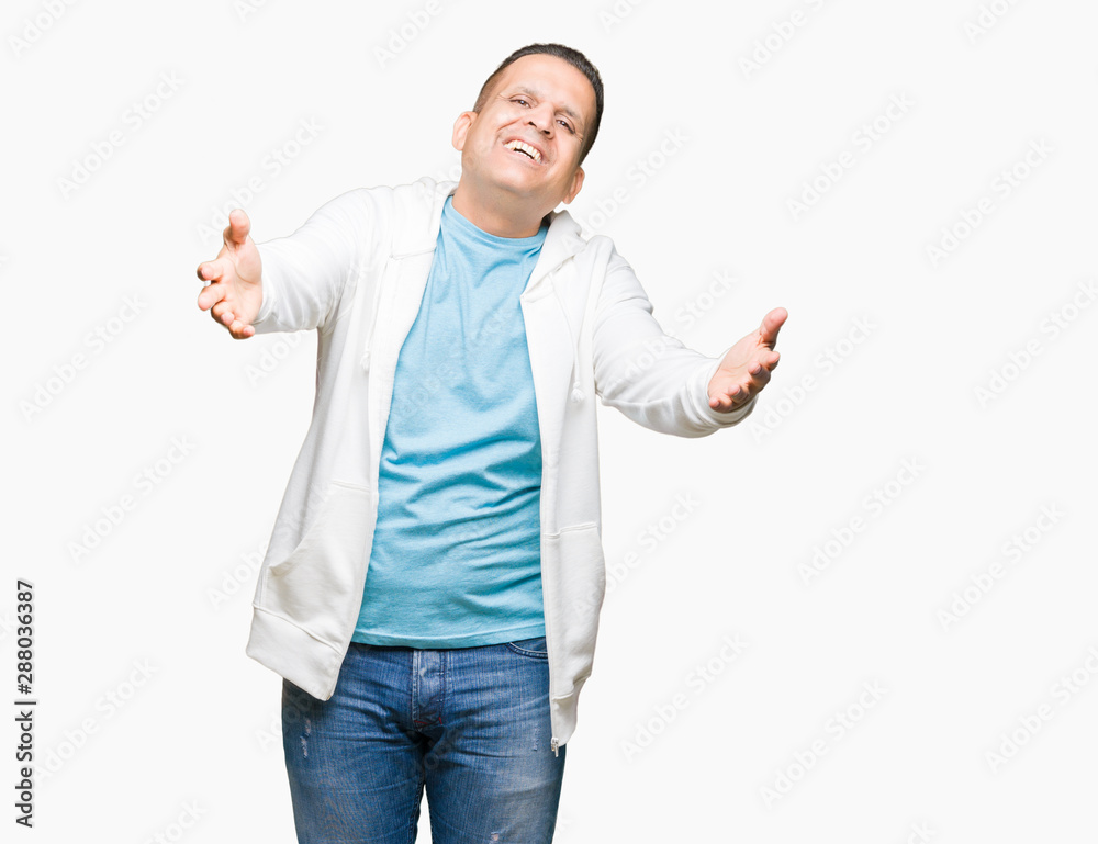 Middle age arab man wearing sweatshirt over isolated background looking at the camera smiling with open arms for hug. Cheerful expression embracing happiness. Middle age arab man wearing sweatshirt over isolated background looking at the camera smiling with open arms for hug. Cheerful expression embracing happiness.