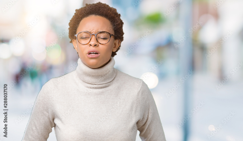 Young beautiful african american woman wearing glasses over isolated background with hand on stomach because indigestion, painful illness feeling unwell. Ache concept. Young beautiful african american woman wearing glasses over isolated background with hand on stomach because indigestion, painful illness feeling unwell. Ache concept.