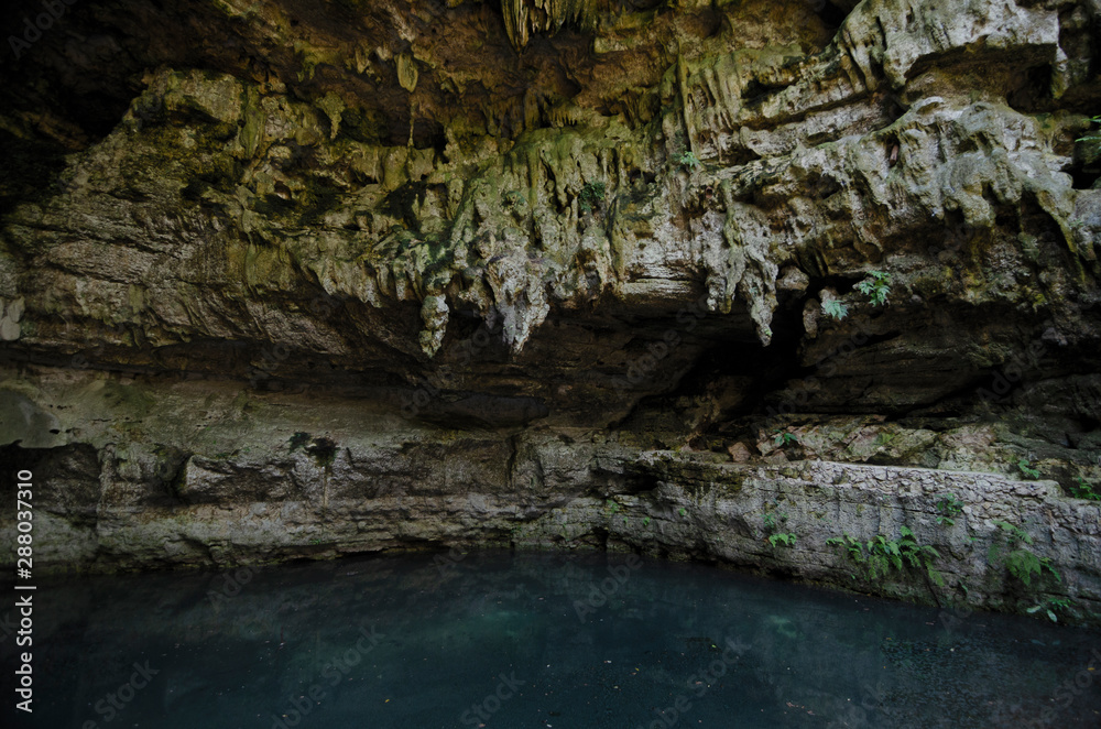 Stalactites and blue pool of undeground lake.