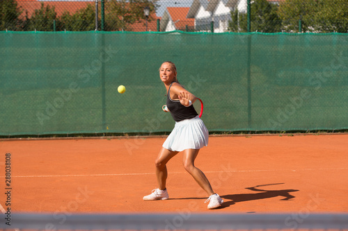 Tennis - woman hitting tennis ball © Tom Kuest