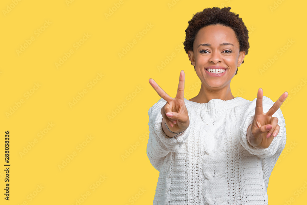 Beautiful young african american woman wearing sweater over isolated background smiling looking to the camera showing fingers doing victory sign. Number two.