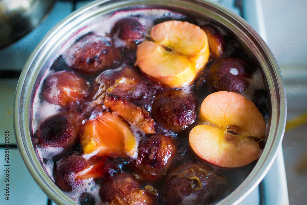 Stewed apples, peaches and plums are cooked in a pan