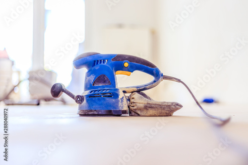 Renovating at home: sander tool for refreshing and grinding the wooden parquet floor