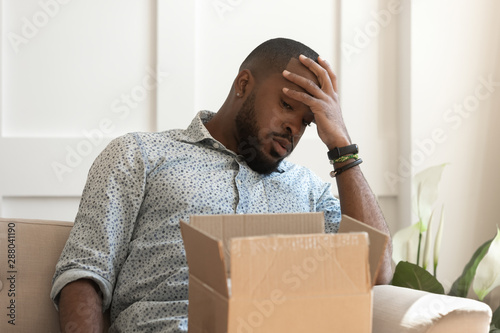 Unhappy african american male recipient recieved damaged item. photo