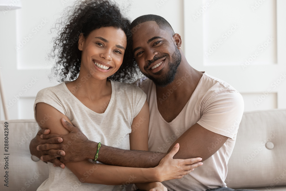 Happy young smiling cuddling african american family portrait.