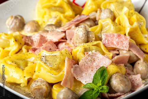 Ravioli pasta with cream, mushrooms and ham