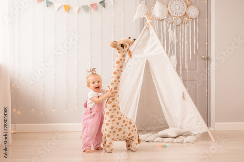 baby girl in the nursery playing,bright children's room, textiles for children's room photo