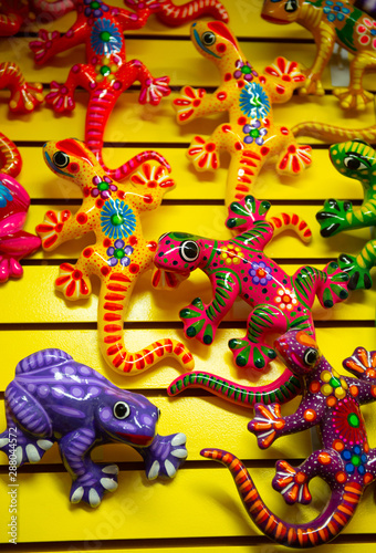 Brightly colored ceramic lizards and frogs on yellow wall