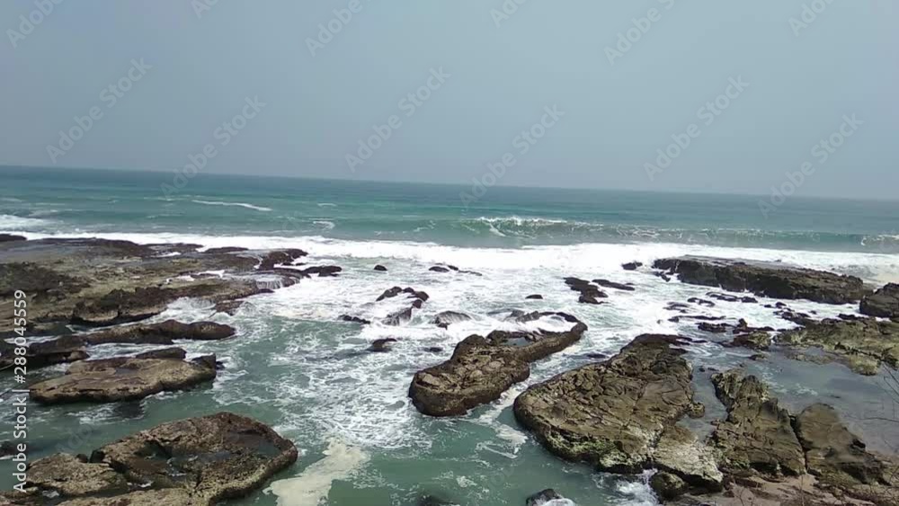 Top view of breaking waves on rock with big footprint Top view of breaking waves on rock with big footprint