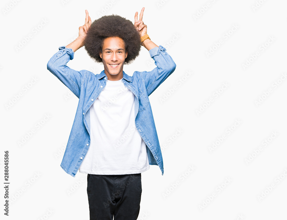 Young african american man with afro hair Posing funny and crazy with fingers on head as bunny ears, smiling cheerful Young african american man with afro hair Posing funny and crazy with fingers on head as bunny ears, smiling cheerful