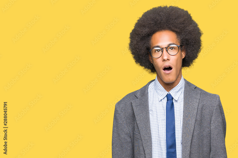 Young african american business man with afro hair wearing glasses In shock face, looking skeptical and sarcastic, surprised with open mouth Young african american business man with afro hair wearing glasses In shock face, looking skeptical and sarcastic, surprised with open mouth