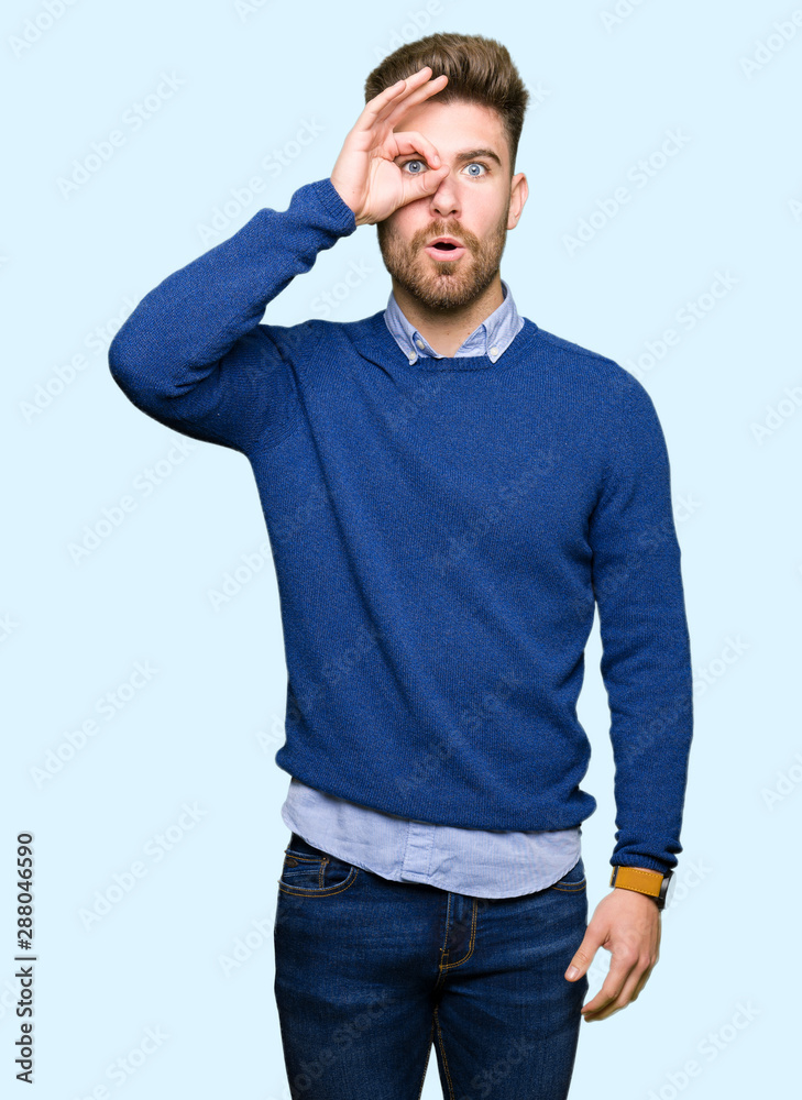 Young handsome bussines man doing ok gesture shocked with surprised face, eye looking through fingers. Unbelieving expression. Young handsome bussines man doing ok gesture shocked with surprised face, eye looking through fingers. Unbelieving expression.