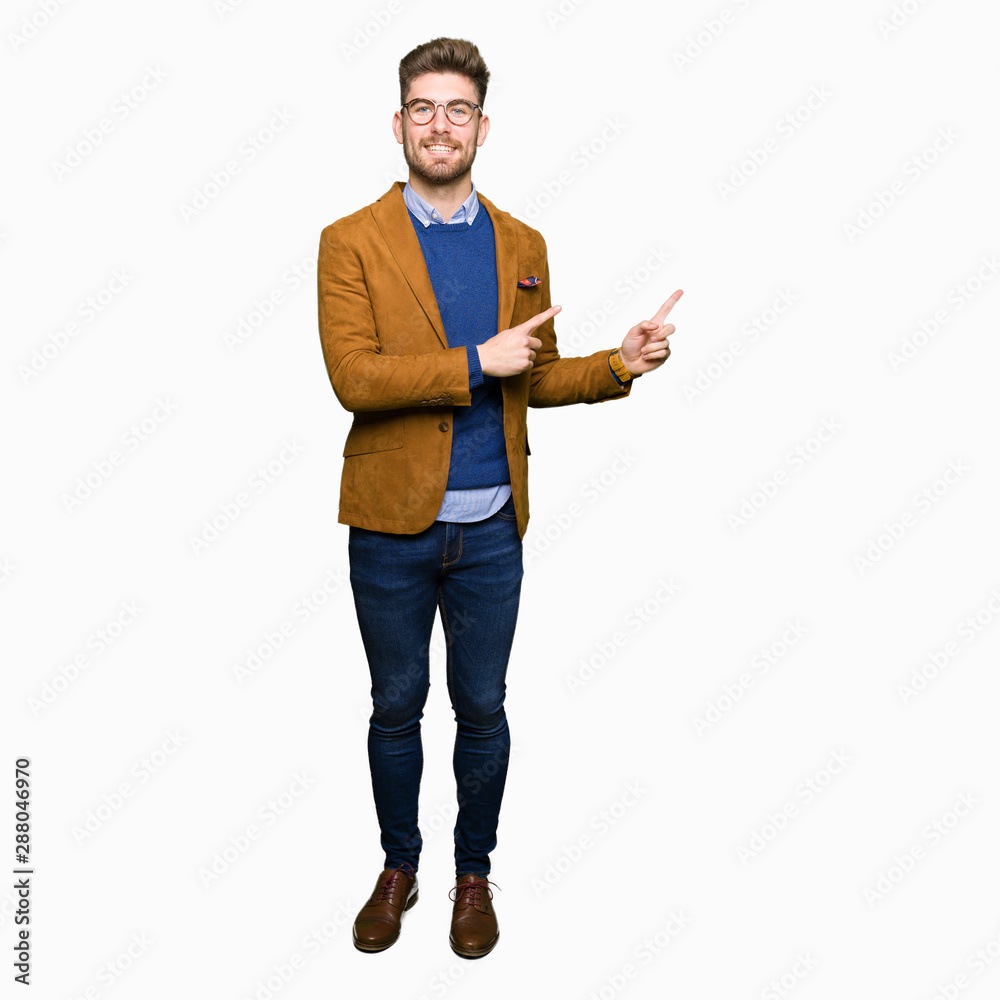 Young handsome business man wearing glasses smiling and looking at the camera pointing with two hands and fingers to the side. Young handsome business man wearing glasses smiling and looking at the camera pointing with two hands and fingers to the side.