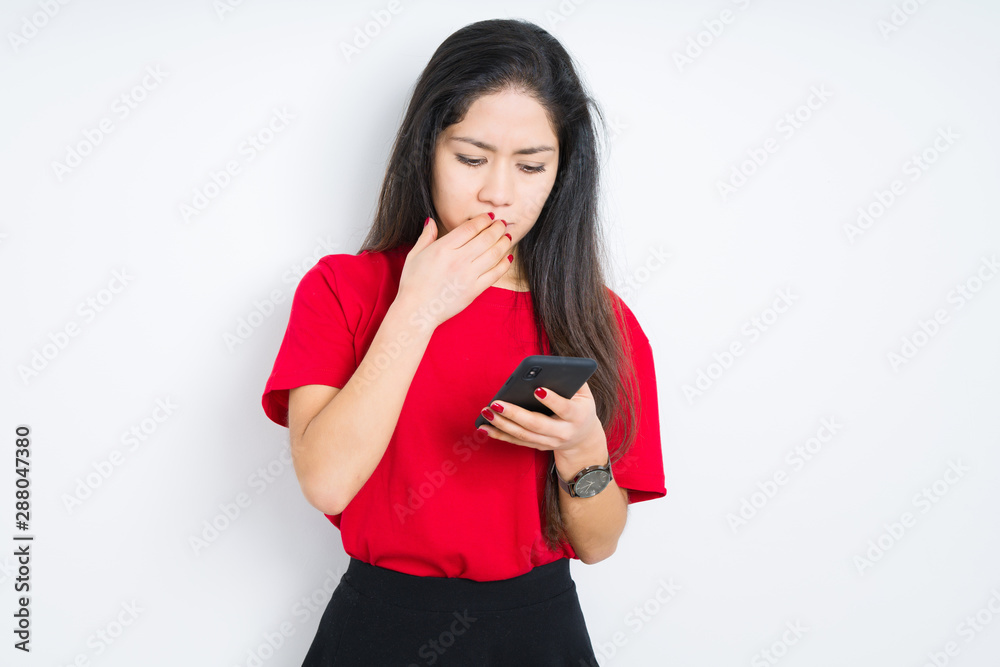 Young brunette woman using smartphone over isolated background cover mouth with hand shocked with shame for mistake, expression of fear, scared in silence, secret concept Young brunette woman using smartphone over isolated background cover mouth with hand shocked with shame for mistake, expression of fear, scared in silence, secret concept