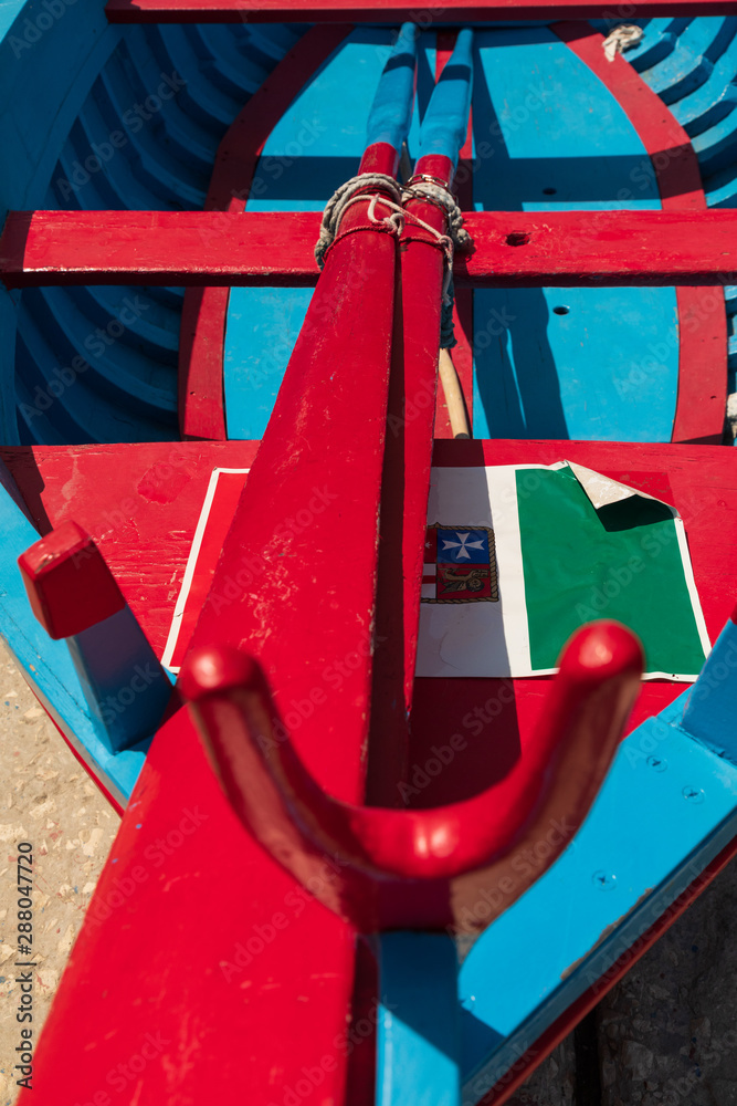 Italy, Apulia, Metropolitan City of Bari, Monopoli. Porto di Monopoli. Close-up of a blue and red fishing boat.