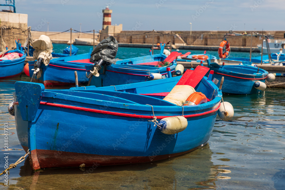 Obraz premium Italy, Apulia, Metropolitan City of Bari, Monopoli. Porto di Monopoli. Blue and red fishing boats in the harbor.