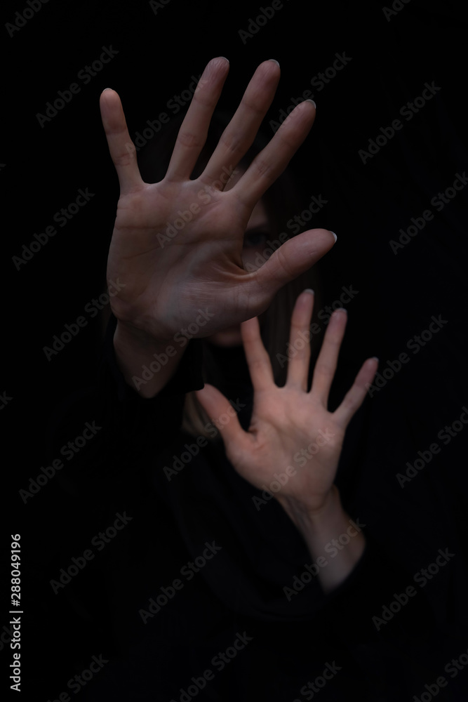 Fototapeta premium Woman showing stop gesture, feeling fear, trying to stop physical abuse, defending and hiding herself.