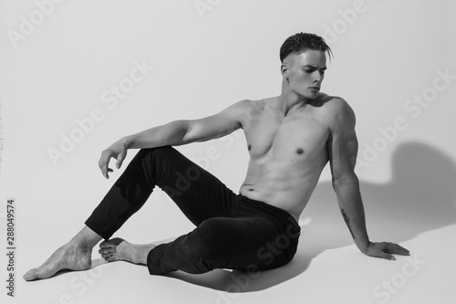 Black and White Muscle strong beautiful stripped male model with white underwear in denim jeans on white isolated font background