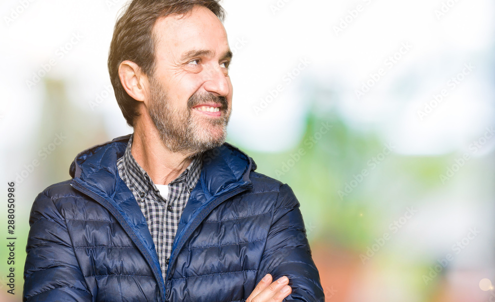 Middle age handsome man wearing winter coat smiling looking side and staring away thinking. Middle age handsome man wearing winter coat smiling looking side and staring away thinking.