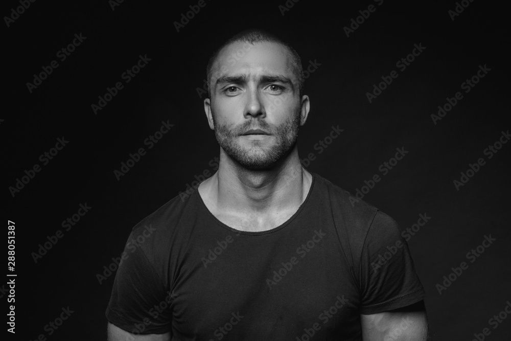 Black and White Muscle strong beautiful stripped male model with black t-shirt in denim blue jeans on black isolated font background