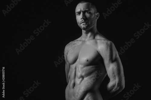 Black and White Handsome sport sexy stripped guy portrait for cosmetics and fitness drops on isolated black background
