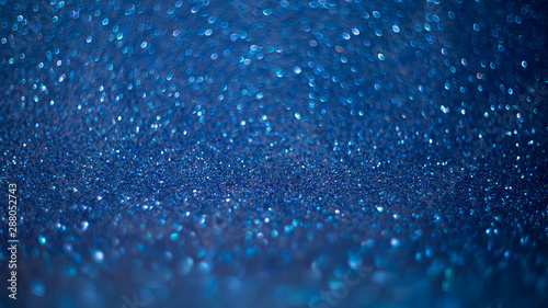 Blue defocused glitter background with bokeh copy space