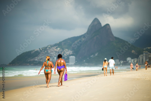 Bright morning view of Ipanema Beach with tropical clouds hovering over Two Brothers Mountain in Rio de Janeiro, Brazil
